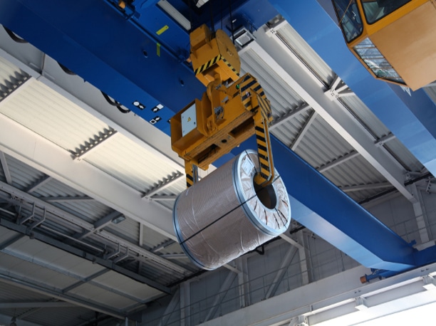 Coil packaging being transported on a crane